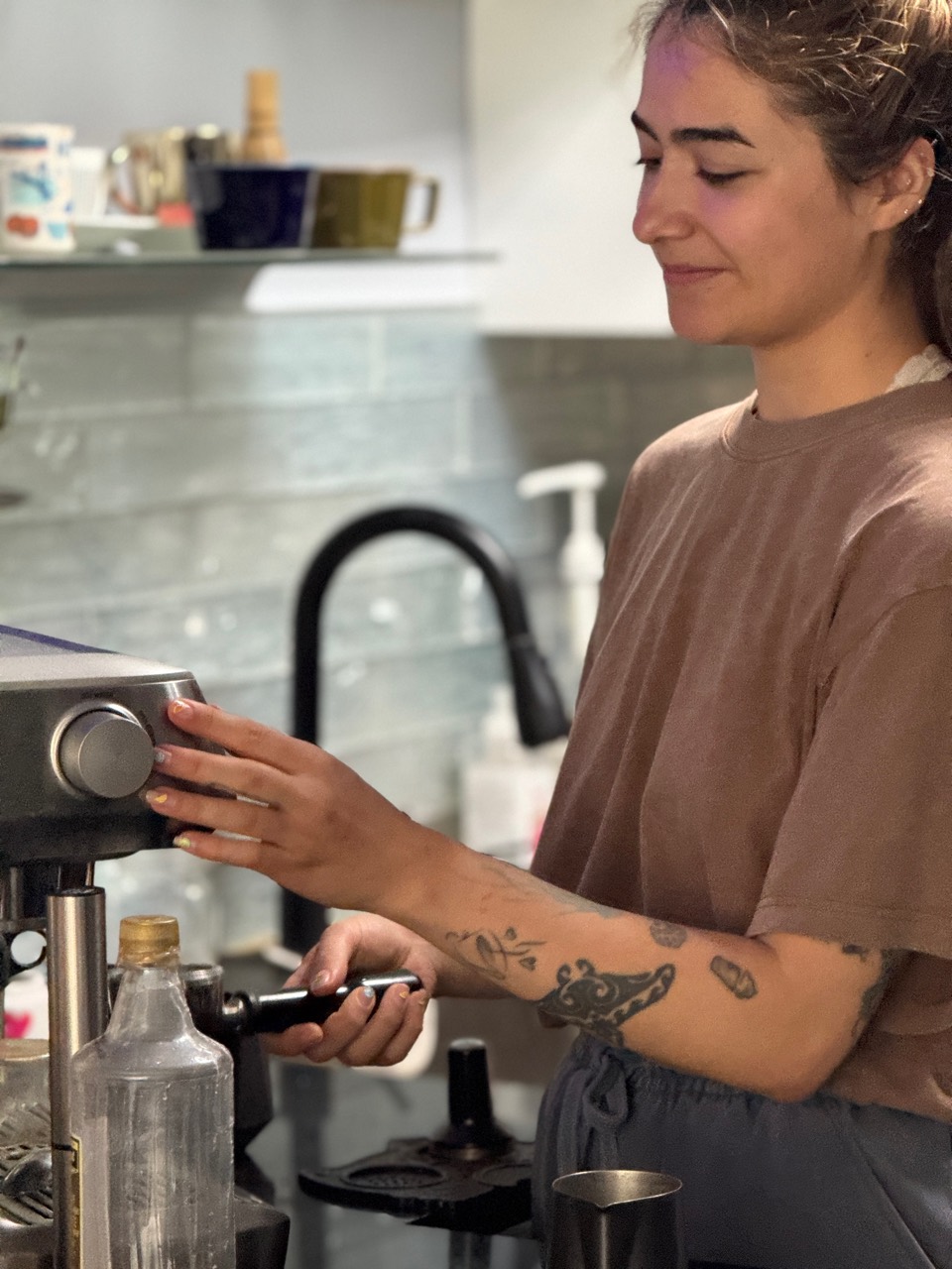 Bianca holding an espresso portafilter and smiling.