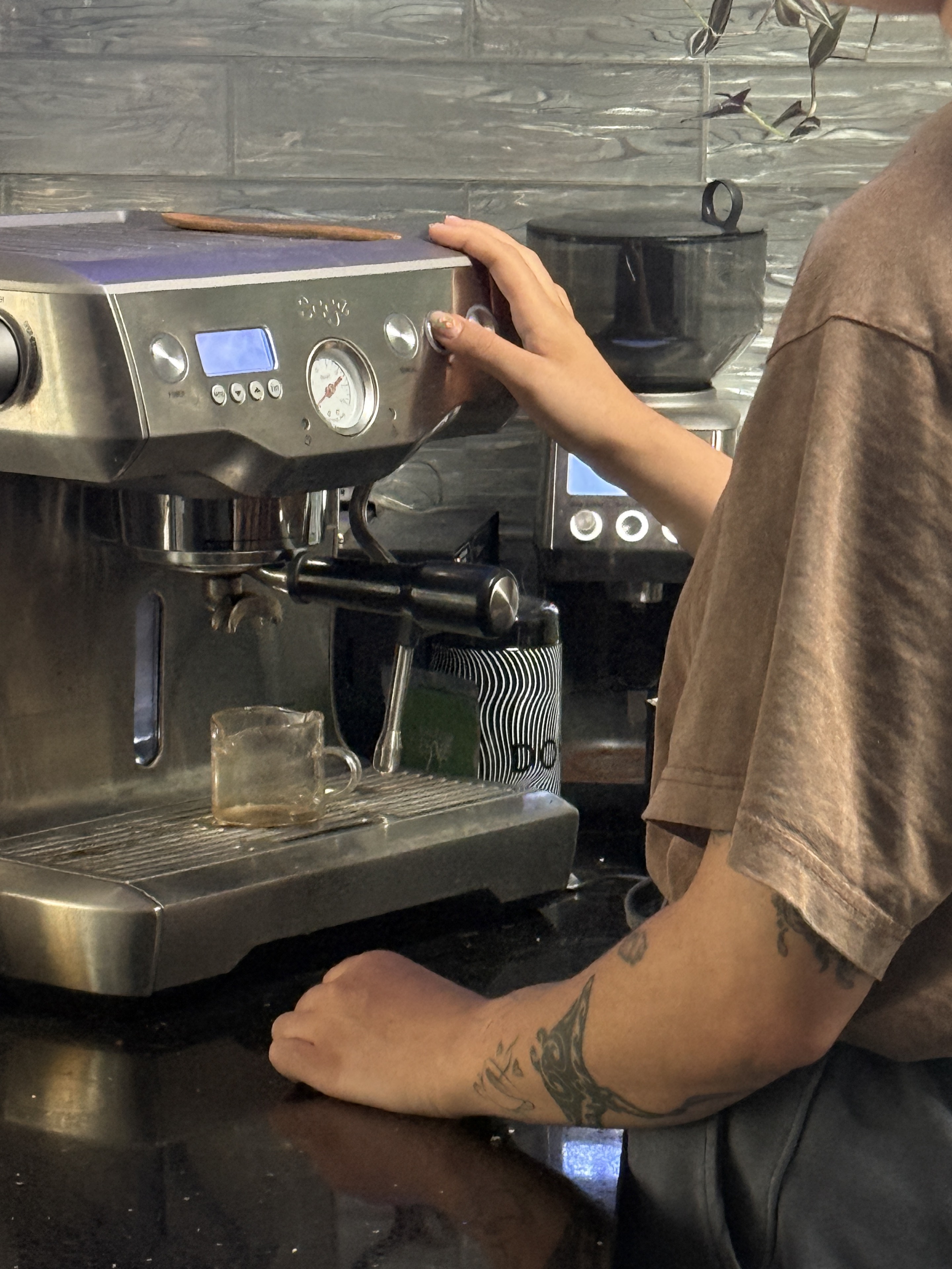 Close detail of Bianca operating an espresso machine.