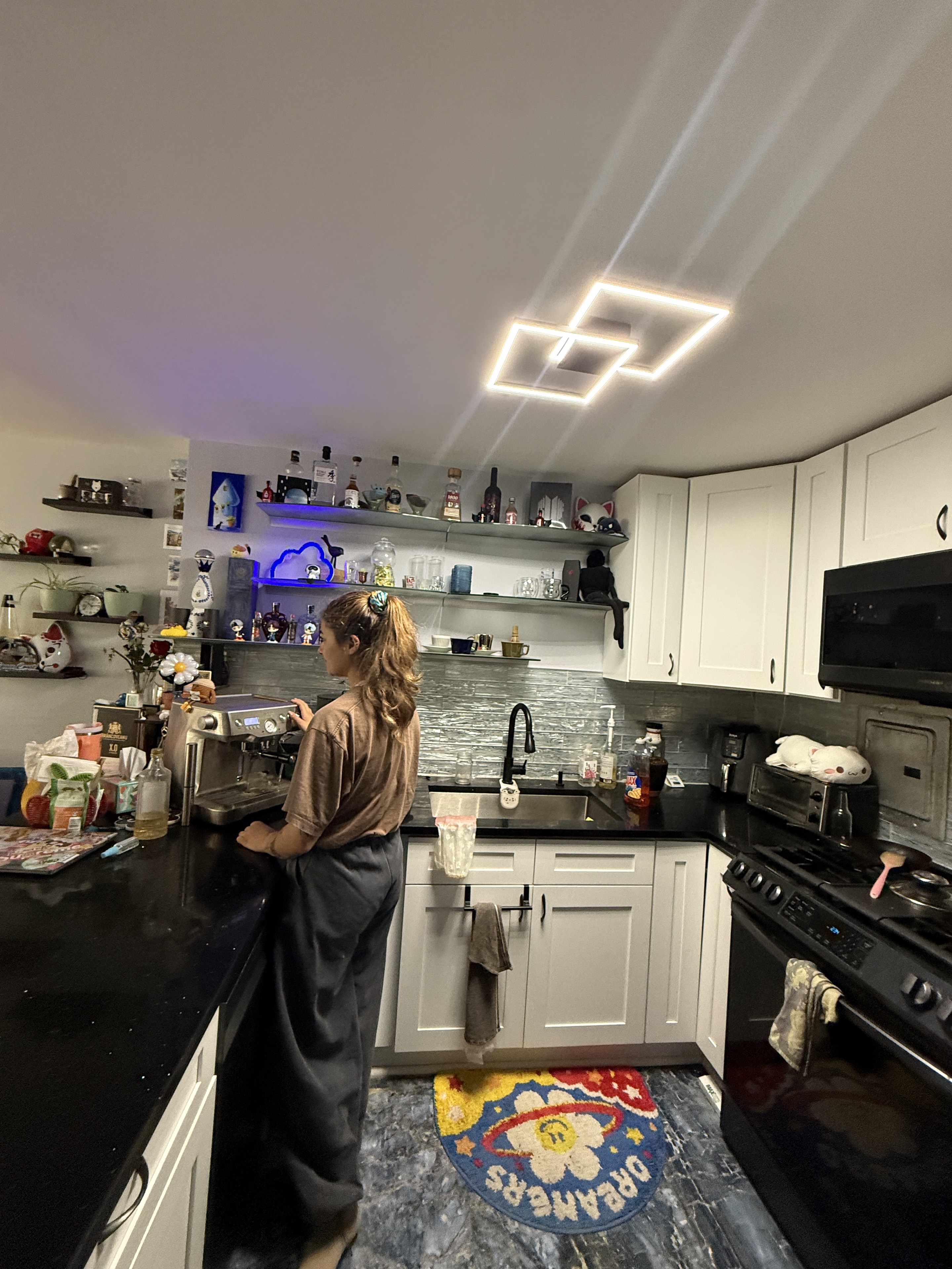Wide view of Bianca at a coffee station with warm light.